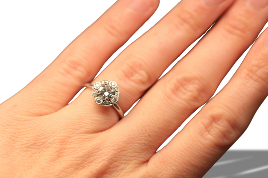 Laurence Bruyninckx 18K white gold diamond halo ring shown on hand against a white background