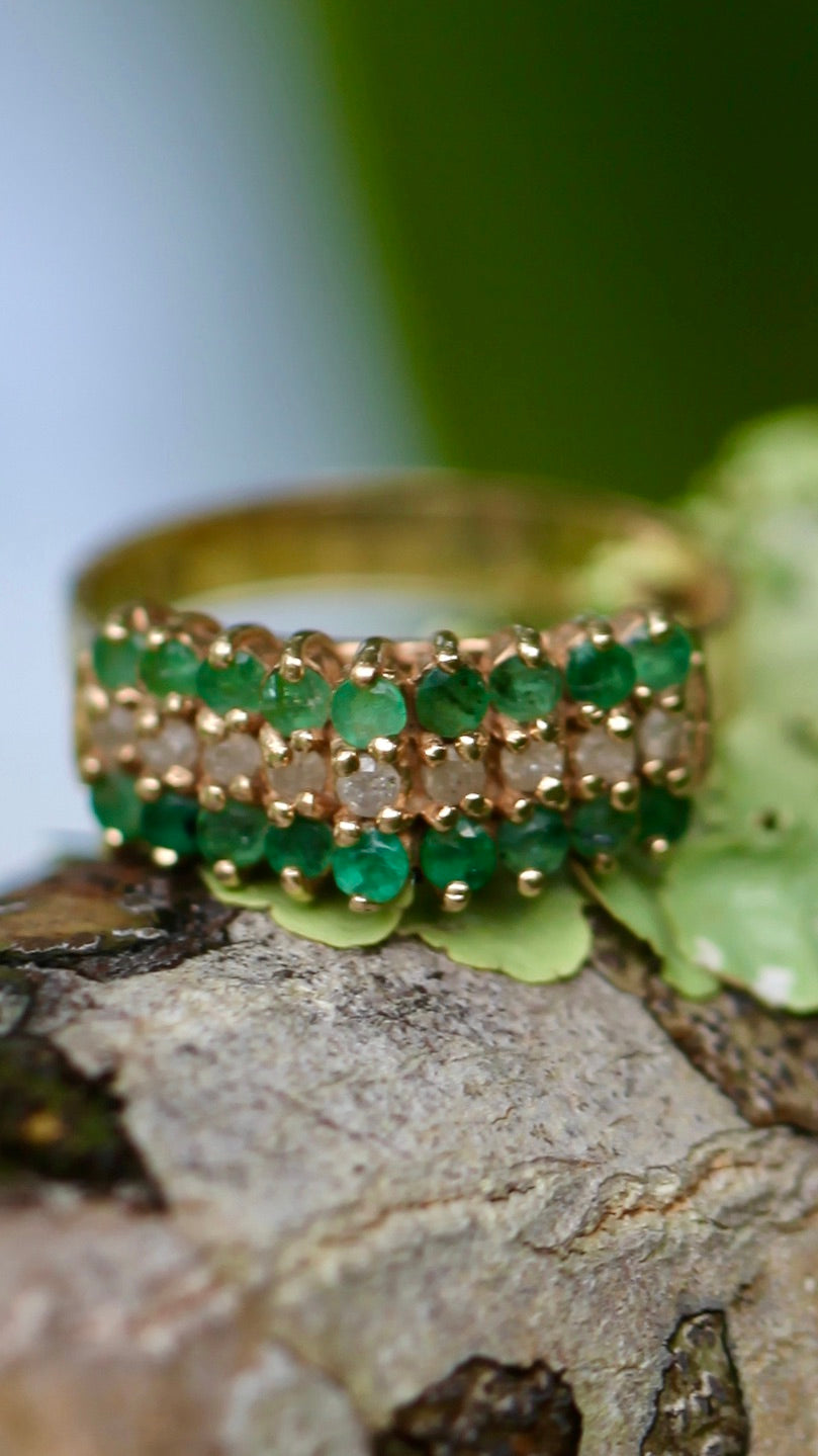 Vintage 14K yellow gold emerald and diamond pyramid cocktail ring displayed on tree bark with green leaves background