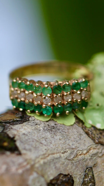 Vintage 14K yellow gold emerald and diamond pyramid cocktail ring displayed on tree bark with green leaves background