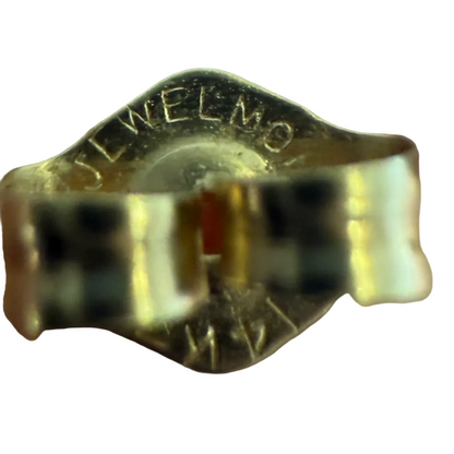 Close-up of a vintage earring butterfly back showing a 14K gold stamp