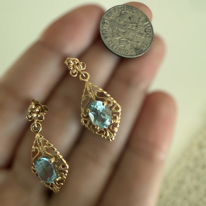 Vintage 14K gold filigree aquamarine drop earrings shown on hand next to a coin for scale