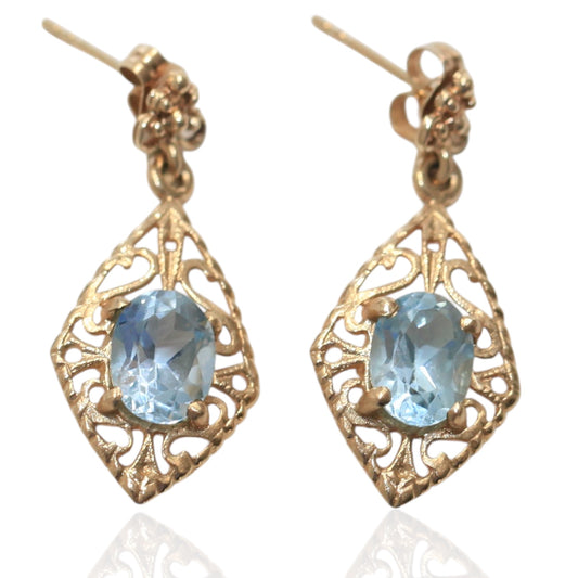 Vintage 14K gold filigree earrings with oval aquamarine gemstones on a white background