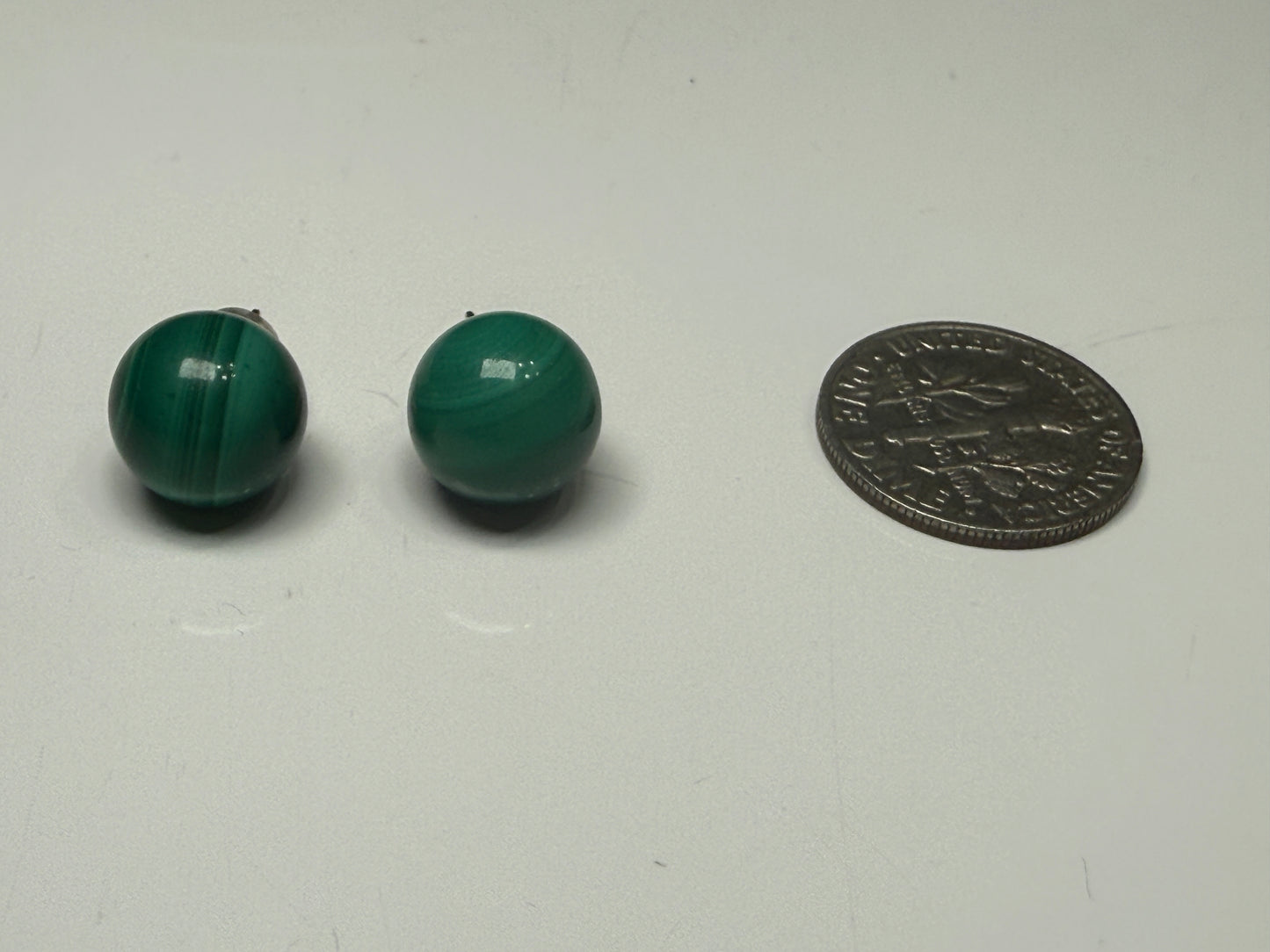 Pair of green malachite stud earrings shown beside a U.S. dime for size reference
