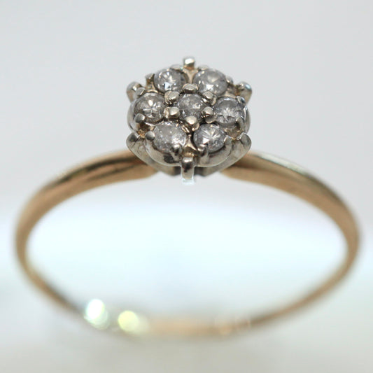 1950s vintage 10K two-tone gold engagement ring with seven round diamond floral cluster, size 7.75, on light background