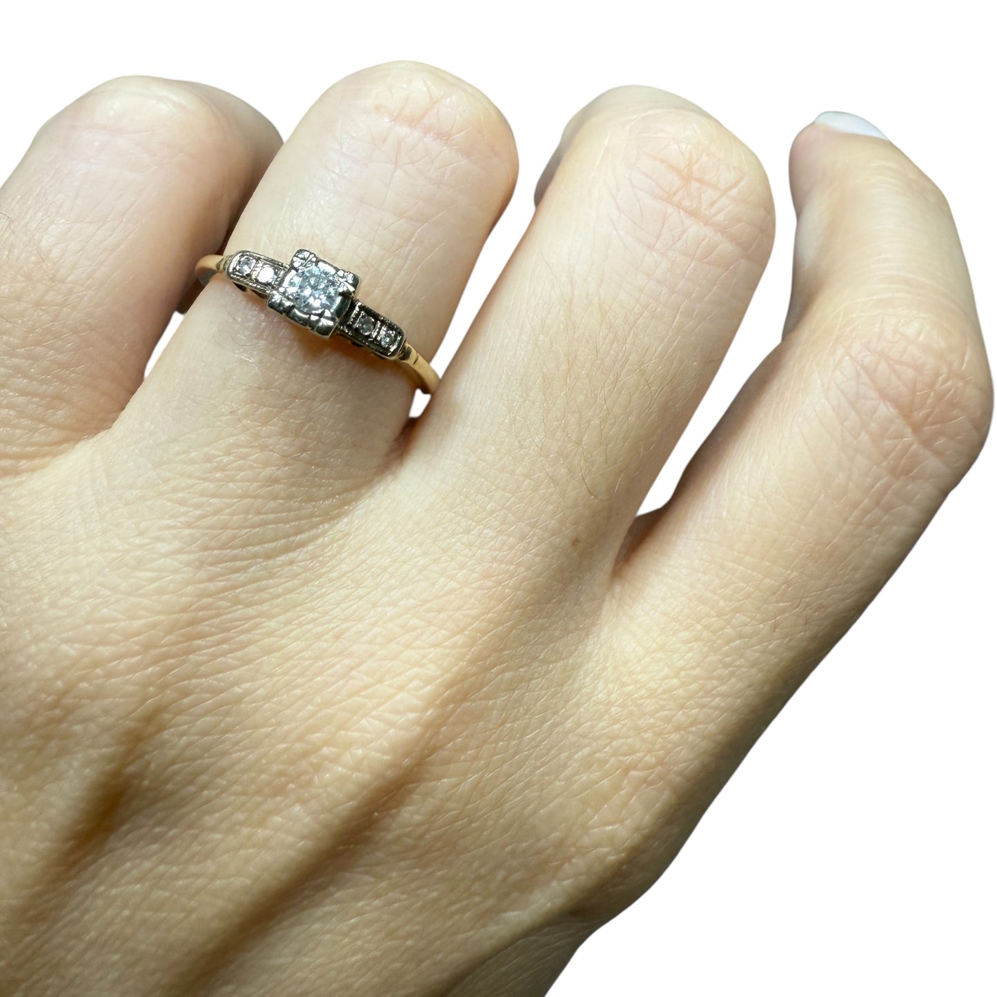 1940s vintage 14K two-tone diamond engagement ring with illusion head and stepped shoulders, shown on hand top view (size 5.5).