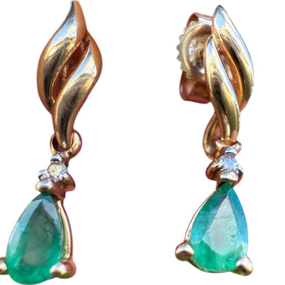 Close-up of 1990s vintage 10K yellow gold emerald and diamond dangle earrings