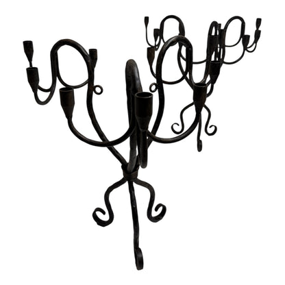 Vintage hand-wrought iron candelabra with scrolling forged arms and dark patina, photographed on a white background.