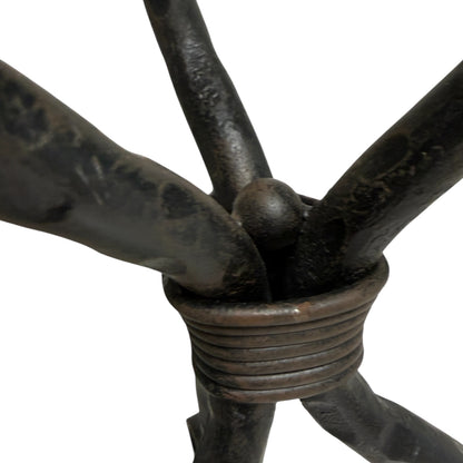 Close-up of the central joint and wrapped iron collar on a wrought iron candelabra, showing aged patina on a white background.