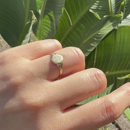 Antique Edwardian 14K gold oval signet ring worn on hand outdoors in natural sunlight