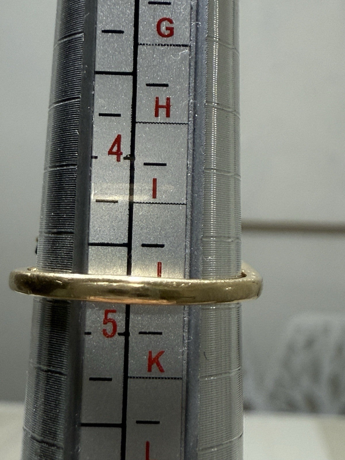 Vintage 1960s 14K gold sapphire and diamond swirl bypass ring shown on a ring mandrel, size 4.5 measurement visible.