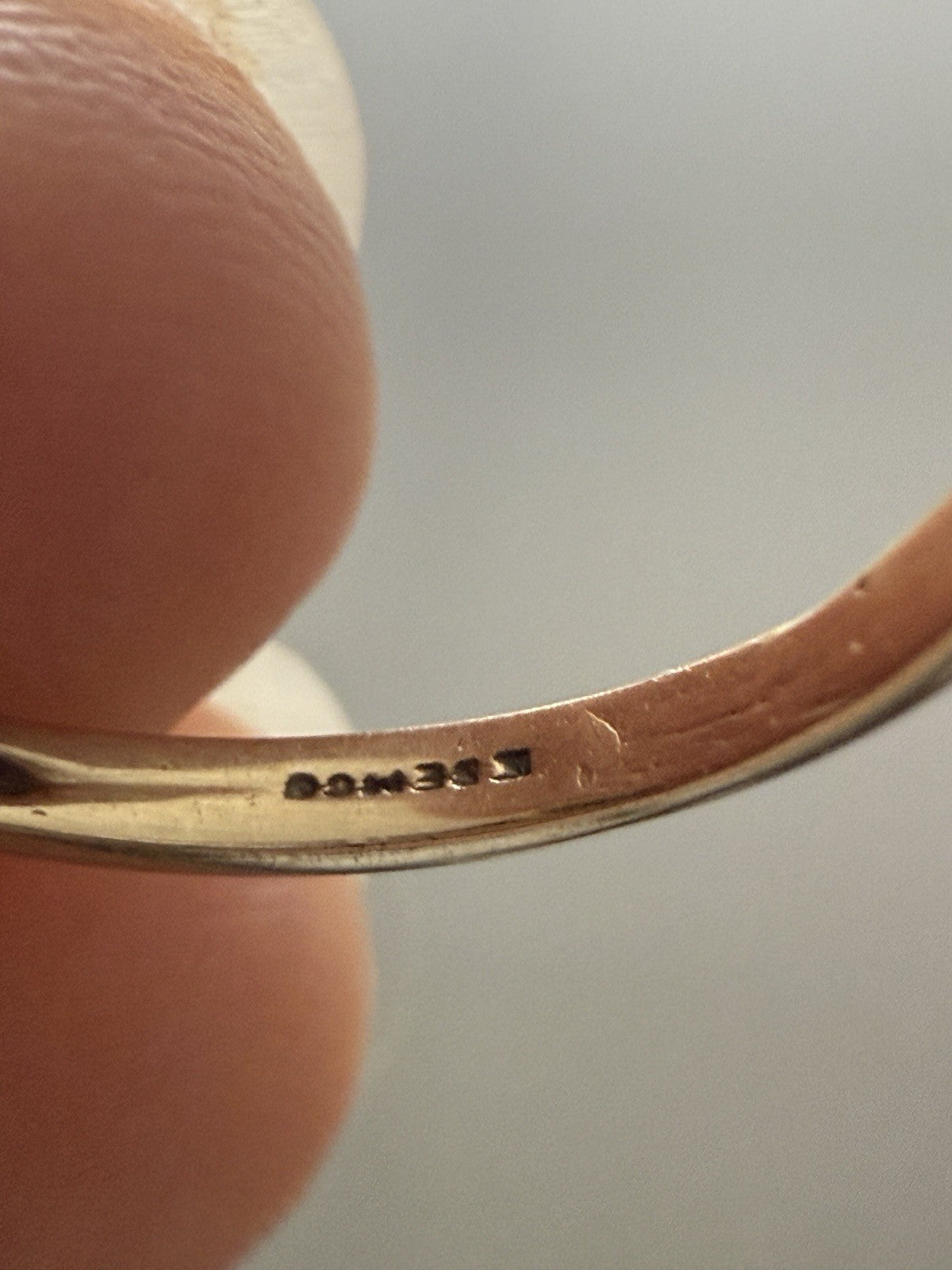 Close-up of the inner band of a 10K yellow gold vintage ring showing the maker’s mark and hallmark stamp.