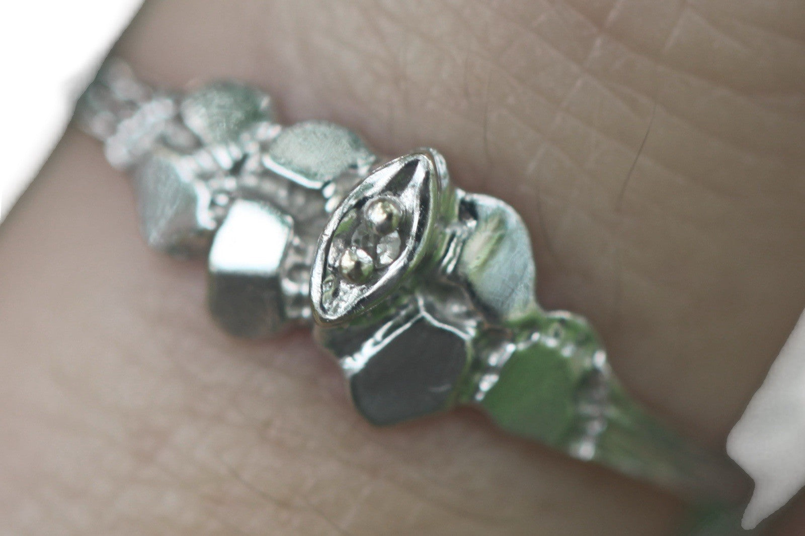 Close-up of 1950s vintage 10K white gold twig band ring with illusion marquise diamond, size 5.75
