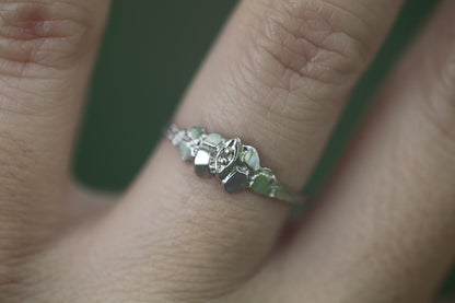 1950s vintage 10K white gold illusion marquise diamond twig band ring on hand against blurred green background