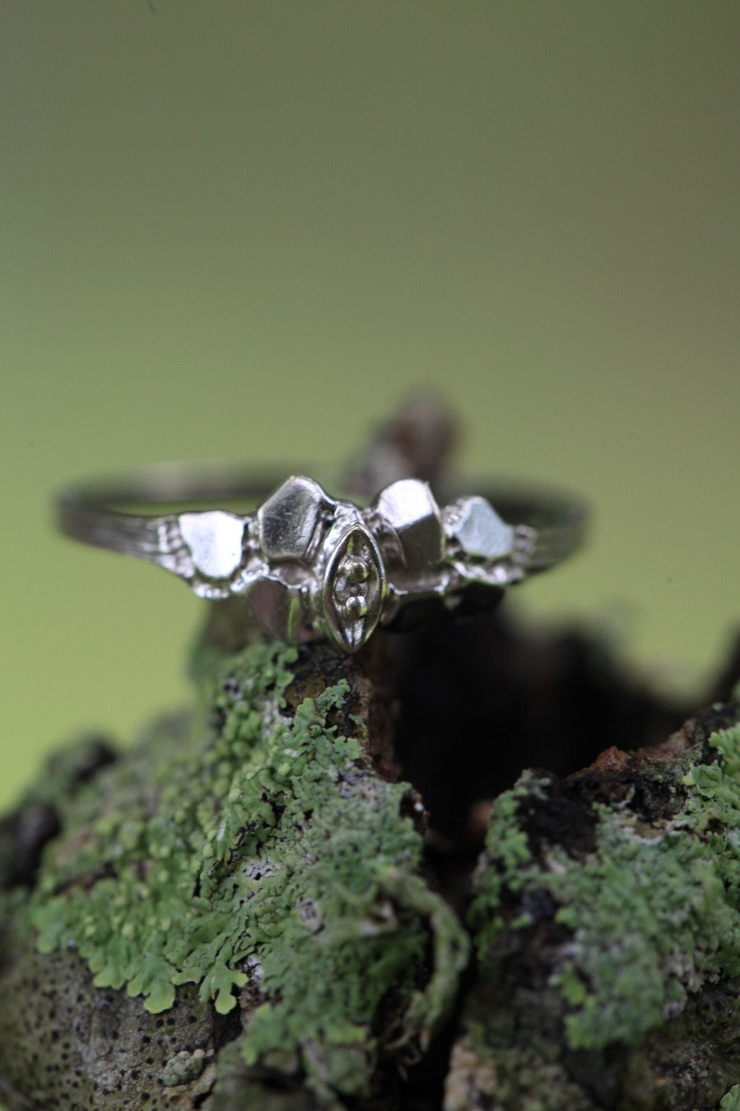 1950s vintage 10K white gold twig band illusion marquise diamond ring on moss background, size 5.75