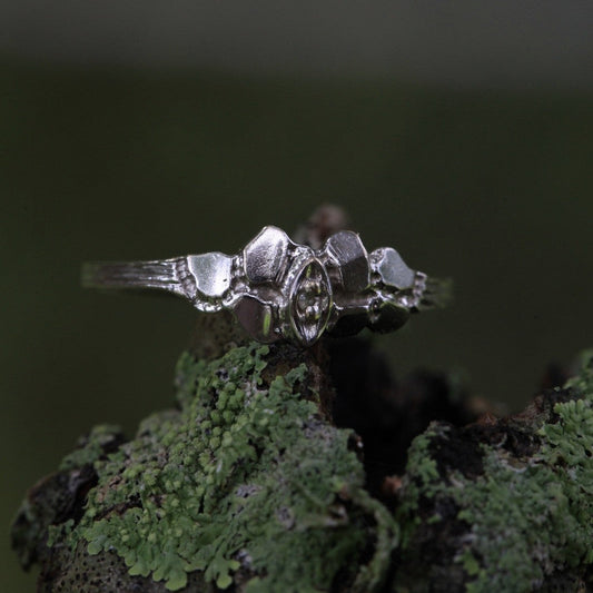 1950s vintage 10K white gold twig band ring with illusion marquise diamond on moss background