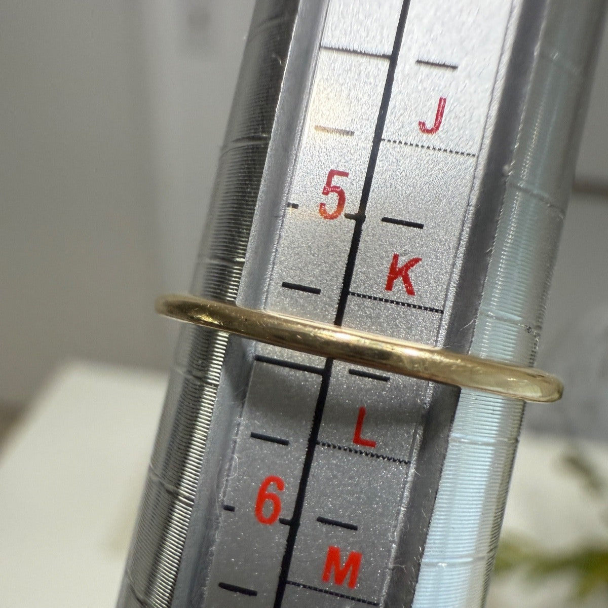 Vintage 1950s 10K gold diamond illusion cluster ring measured on a ring mandrel, showing size slightly over 5.25, closer to 5.375.