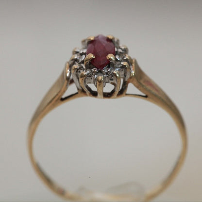 1970s vintage 10K gold ruby and diamond halo ring, marquise cut ruby with raised prong setting and open gallery design