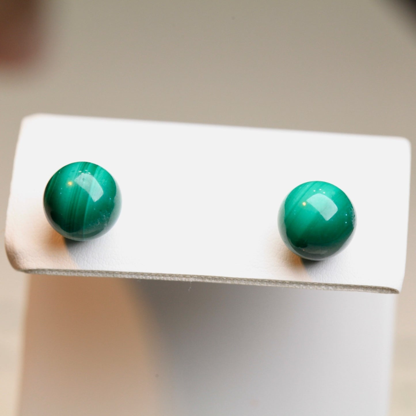 Vintage 1980s 10mm malachite stud earrings displayed on white earring card