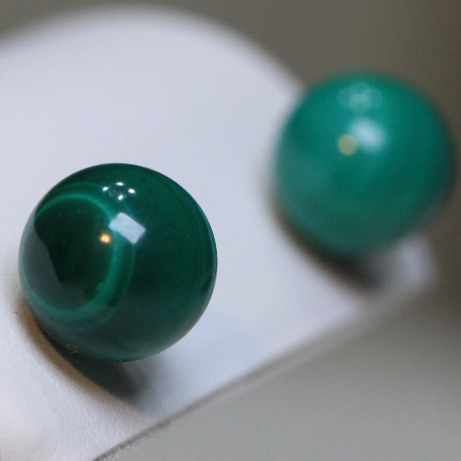 Macro close-up of vintage 1980s 10mm malachite stud earrings showing natural banding