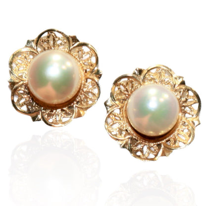 1960s vintage stud earrings featuring luminous cultured pearls set in intricate 14K yellow gold filigree with a delicate floral motif.