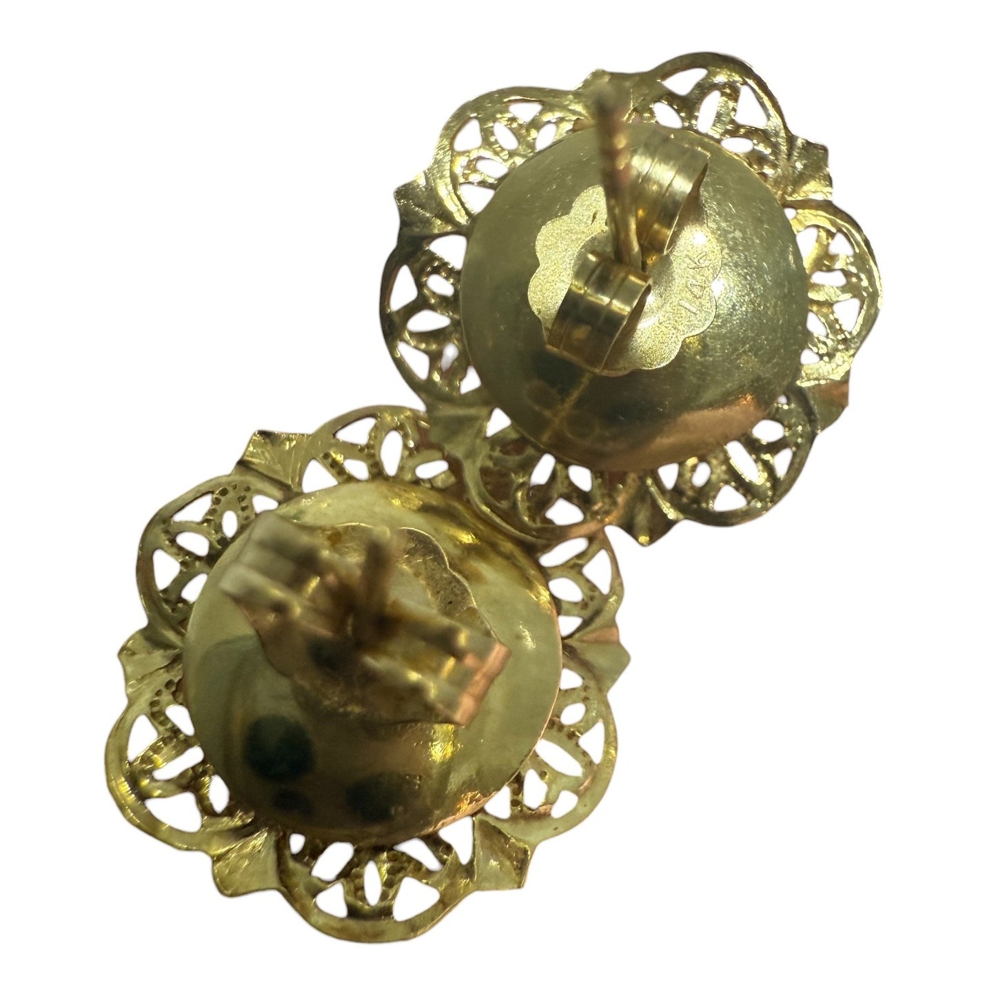 Back view of vintage 14K gold pearl stud earrings showing posts and butterfly backs, held between fingers on a white background.