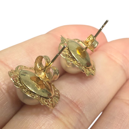 Side view of a vintage 14k gold pearl stud earring showing the post and setting on a white background