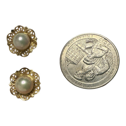Back view of vintage 14k gold pearl stud earrings showing butterfly backs and 14k stamp on a white background