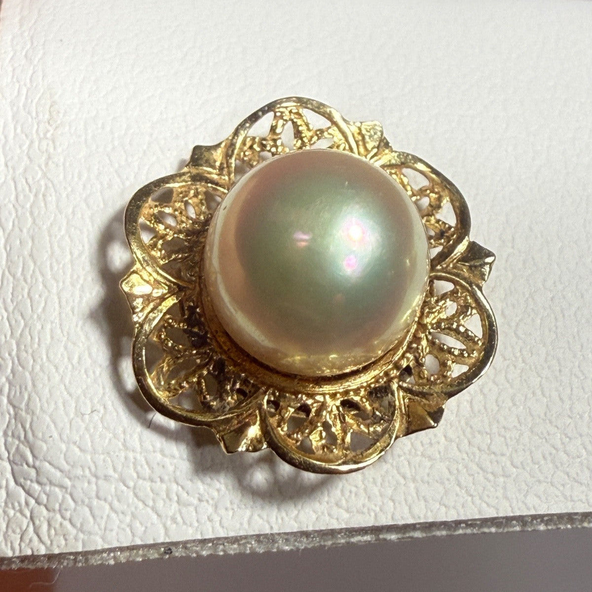 Vintage 1960s 14k gold filigree pearl flower stud earrings displayed on a white jewelry stand