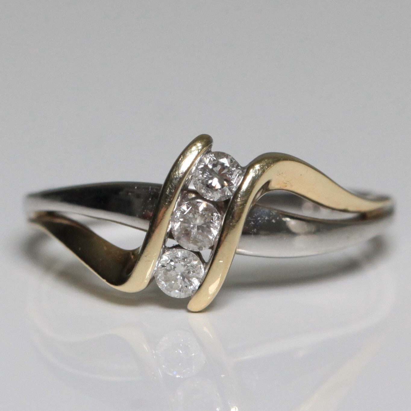 1970s vintage 10K two tone gold diamond bypass ring front view with three round diamonds