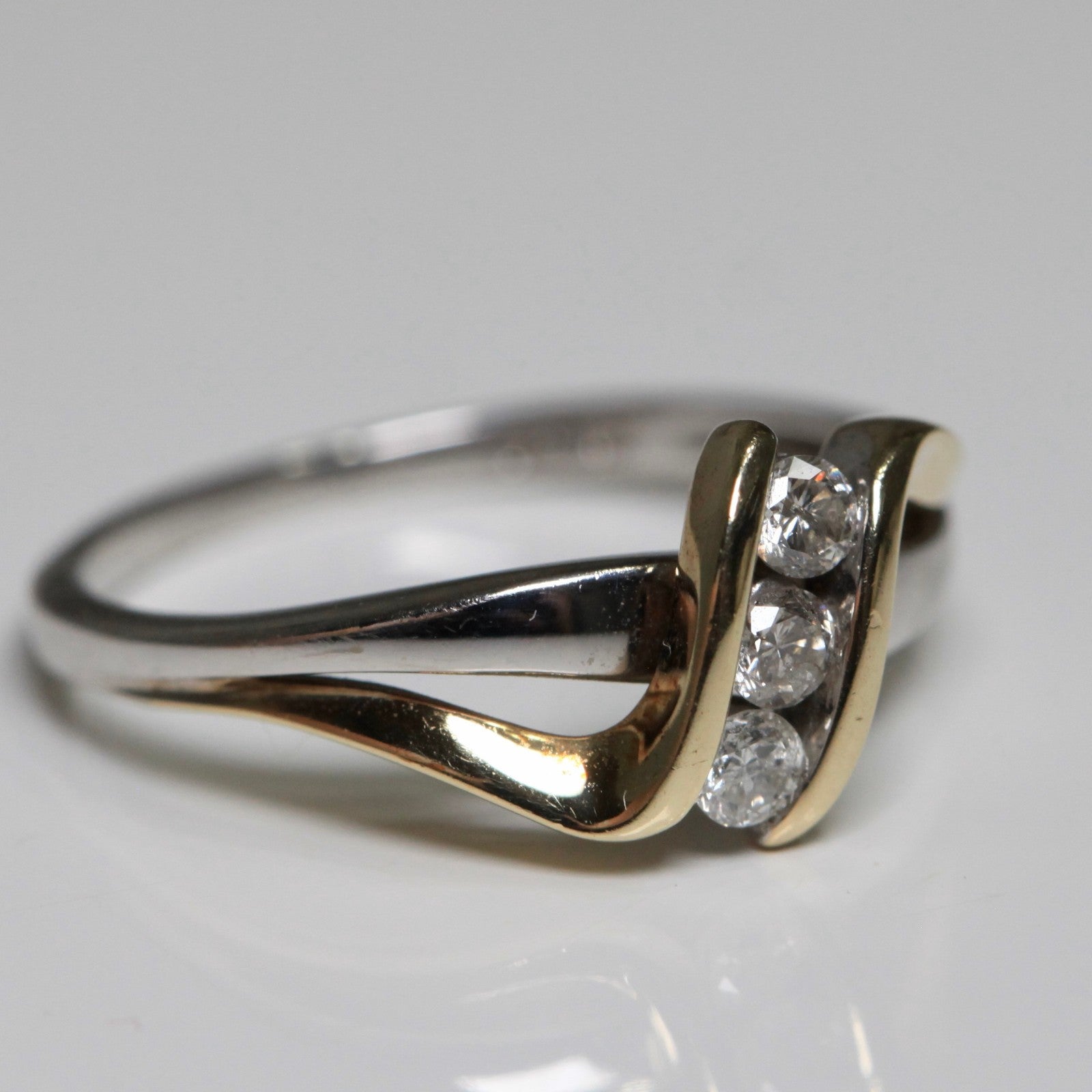 1970s vintage 10K two tone gold diamond bypass ring side view with three round diamonds