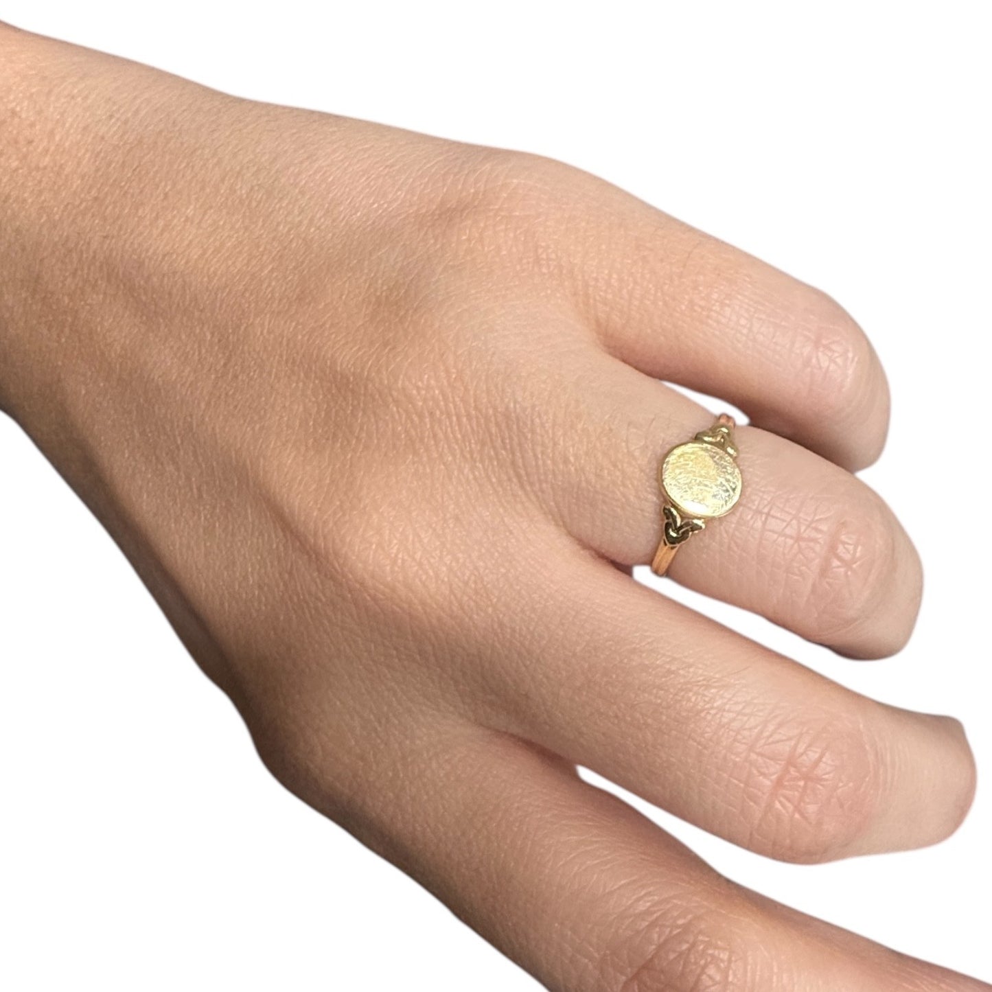 Antique Edwardian 14K gold oval signet ring worn on finger against a white background