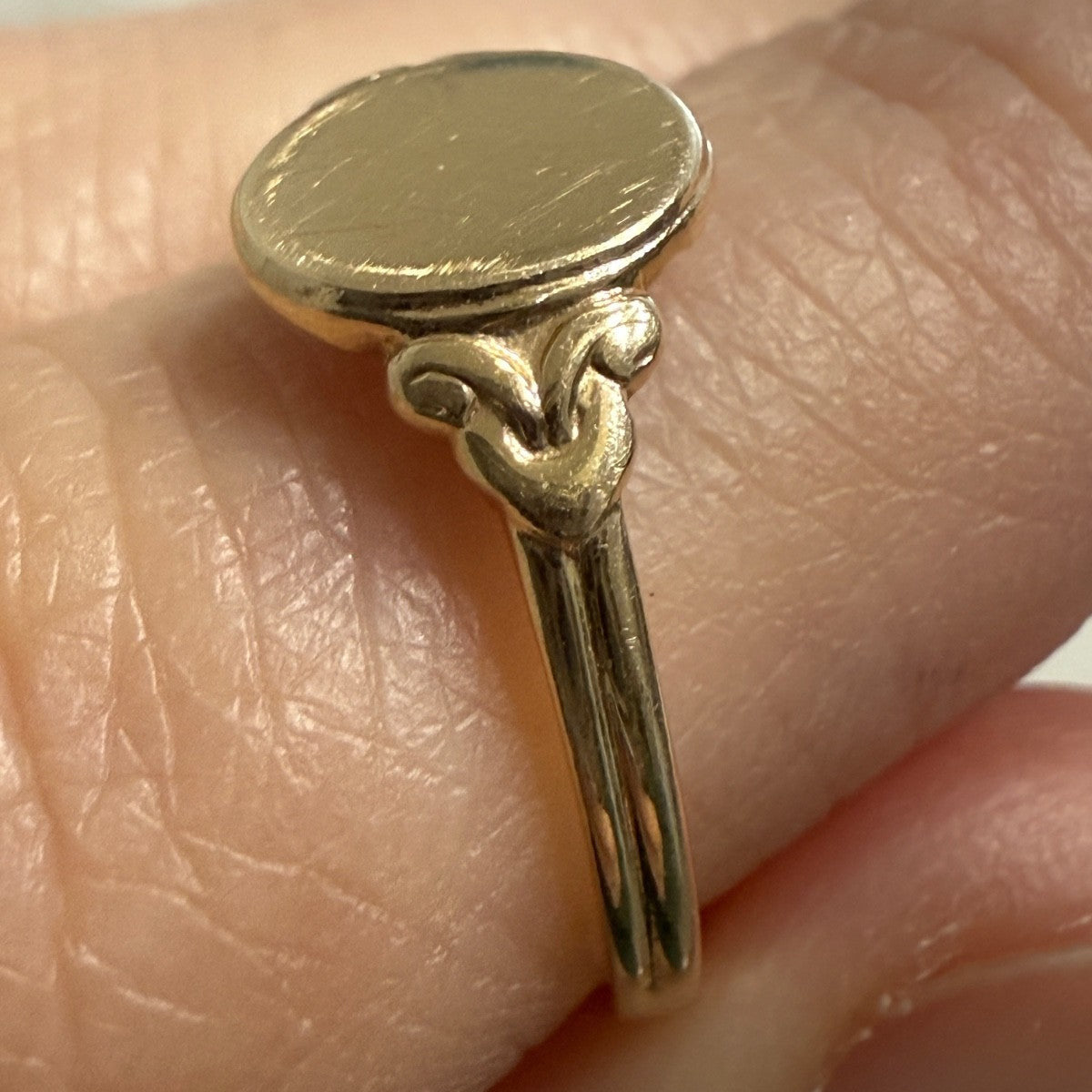 Side profile of antique Edwardian 14K gold oval signet ring showing hand-finished shoulder details