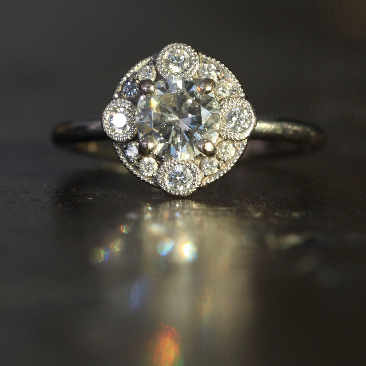 Laurence Bruyninckx 18K white gold diamond halo ring on dark reflective surface