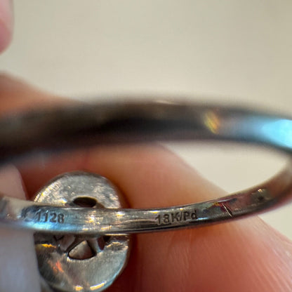 Close-up of an 18K white gold ring shank showing engraved 18K hallmark and maker’s mark