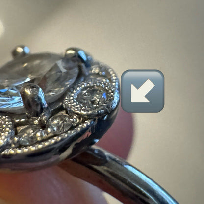 Close-up of an 18K white gold diamond halo ring showing filigree edge and pavé diamond detailing