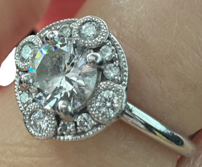 Close-up of Laurence Bruyninckx 18K white gold diamond halo ring shown on finger, featuring round center diamond and pavé halo