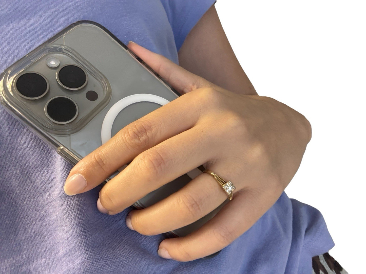 Hand holding a phone while wearing a vintage 14K gold diamond illusion head ring, lifestyle shot on white background